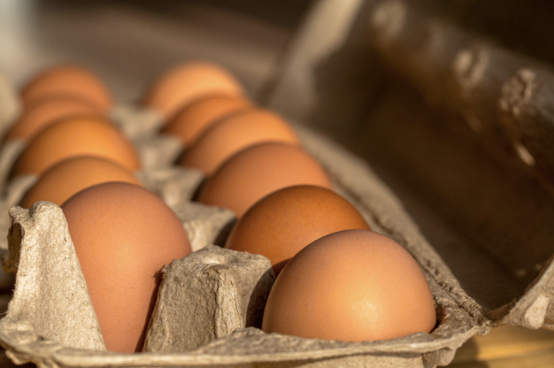 A dozen eggs in a brown carton